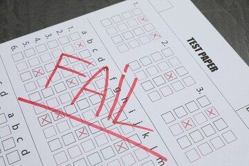 Answer sheet with word Fail on gray table, closeup. Student passing exam