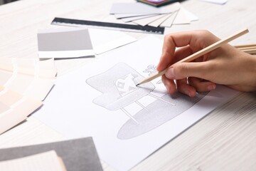 Woman drawing sketch of armchair at white wooden table, closeup