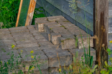 pile of used paving stones near wooden wall