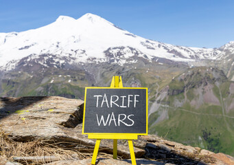 Trade tariff wars symbol. Concept word Tariff wars on beautiful black blackboard. Beautiful stone...