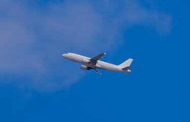 An aircraft after takeoff against a blue sky background