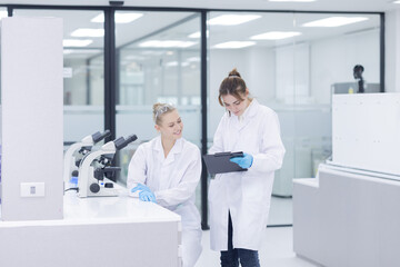 Scientists collaborate in a modern laboratory, sharing results and analyzing data on a tablet