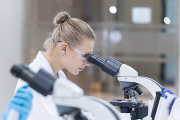 Scientist looking through a microscope in a laboratory