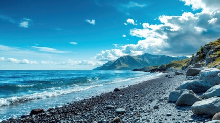 Picturesque beach with black pebbles and waves under a clear blue sky near a mountain range in a coastal area
