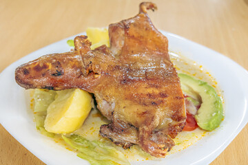 Traditional dish of guinea pig chili or roasted guinea pig, a typical Ecuadorian dish, served with Andean ingredients that highlight the richness, culture, and authentic flavors of Ecuadorian cuisine.
