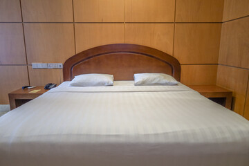 Clean Minimalist Bedroom Interior Featuring Cozy Bed and Wooden Headboard