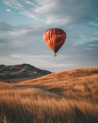 Fototapeta premium Colorful Hot Air Balloon Soaring Over Golden Grassland at Dusk