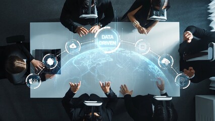 A diverse business team engages in a collaborative session with virtual reality tools while focusing on data-driven strategies in a modern conference room. Raster