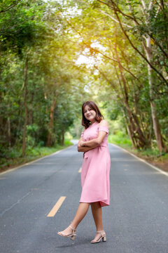 Portrait of a beautiful young woman walking on a road through a lush forest. Portrait of Asian.