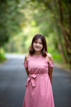 Portrait of a beautiful young woman walking on a road through a lush forest. Portrait of Asian.