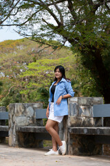 Portrait of a beautiful young woman walking on a road through a lush forest. Portrait of Asian.