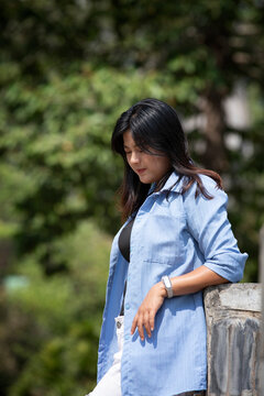 Portrait of a beautiful young woman walking on a road through a lush forest. Portrait of Asian.