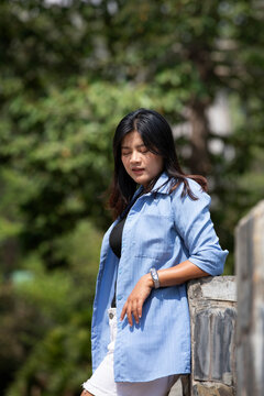 Portrait of a beautiful young woman walking on a road through a lush forest. Portrait of Asian.