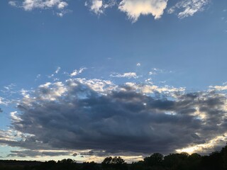 Cloudy sky at sunset, rays of light breaking through the clouds.
