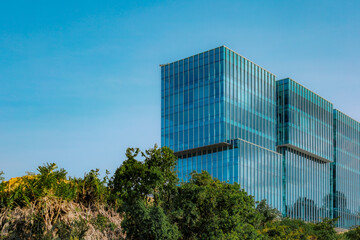 Modern Glass Facade Office Building Against a Clear Blue Sky View