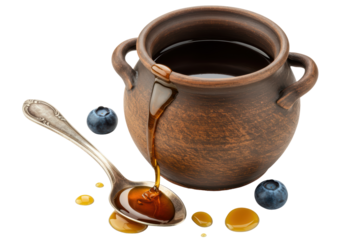 Isolated Honey dripping from earthenware pot into spoon with blueberries for breakfast