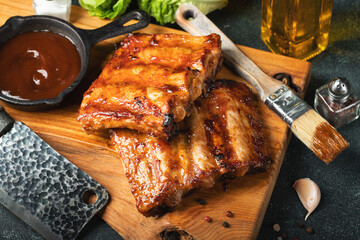 Spicy hot grilled spare ribs from a summer BBQ served with a hot chili pepper and fresh tomatoes