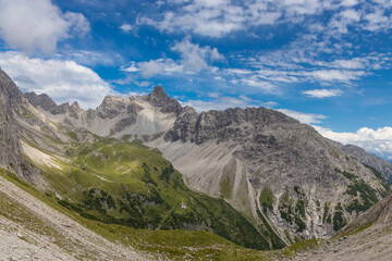 Obraz premium Alps mountains scenic landscape in summer. Austrian Alps scenery trekking path among the high mountain peaks in summer. Green mountain valleys with rocky peaks and lake in the Alps in Austria