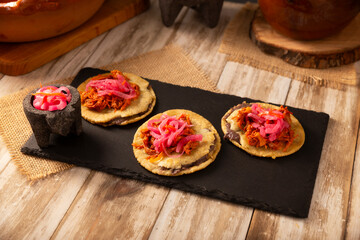 Panuchos, a typical dish from Yucatan, Mexico. A handmade, fried corn tortilla filled with beans,...
