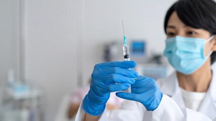 Asian female doctor preparing syringe for vaccination with medical environment. - Powered by Adobe