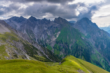 Fototapeta premium Alps mountains scenic landscape in summer. Austrian Alps scenery trekking path among the high mountain peaks in summer. Green mountain valleys with rocky peaks and lake in the Alps in Austria