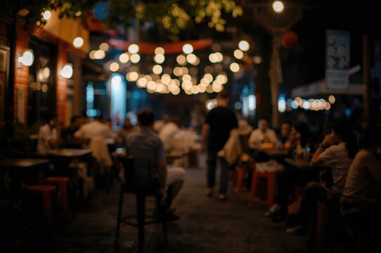 Blurred backdrop of an outdoor beer bar with friends relaxing and enjoying music, celebrating life and leisure in a local street eatery