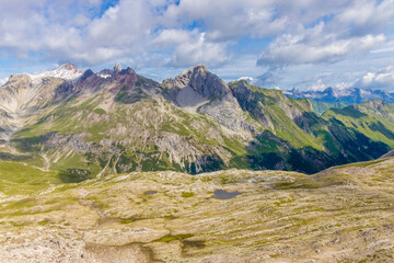 Obraz premium Alps mountains scenic landscape in summer. Austrian Alps scenery trekking path among the high mountain peaks in summer. Green mountain valleys with rocky peaks and lake in the Alps in Austria