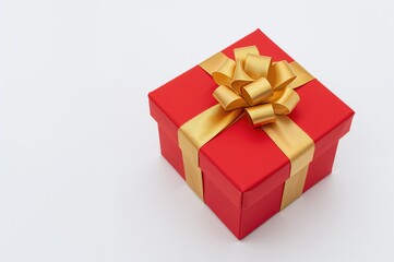 Fototapeta premium Luxury red present box adorned with a golden satin ribbon on a white backdrop, perfect for festive celebrations and special occasions.