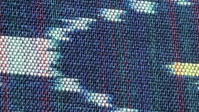 Handwoven ikat textile featuring colorful geometric patterns. Perfect for backgrounds, fashion, interior design, and cultural themes.