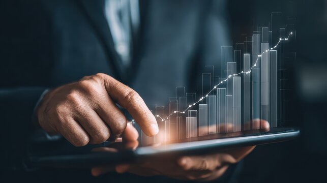 photo of businessman analyzing financial growth chart with rising arrow and wind turbine representing sustainable business development and green energy investment