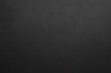 Blank grey wall with dark charcoal and black wooden tabletop, ideal for showcasing products in a rustic style with ample space for text.