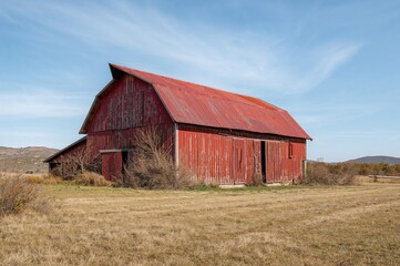 Obraz premium Spacious vintage crimson barn in rural area