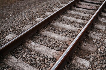 Close-up of weathered railway tracks featuring stones and concrete ties