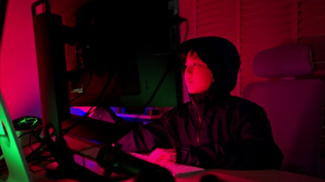 A boy wearing headsets and enjoying online gaming together in a neon lit room