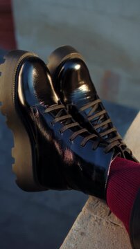 Close-up of shiny black boots with thick soles and red socks