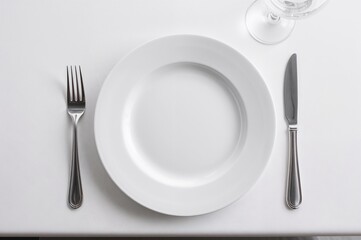 Cutlery arranged on a white dish set atop a white surface