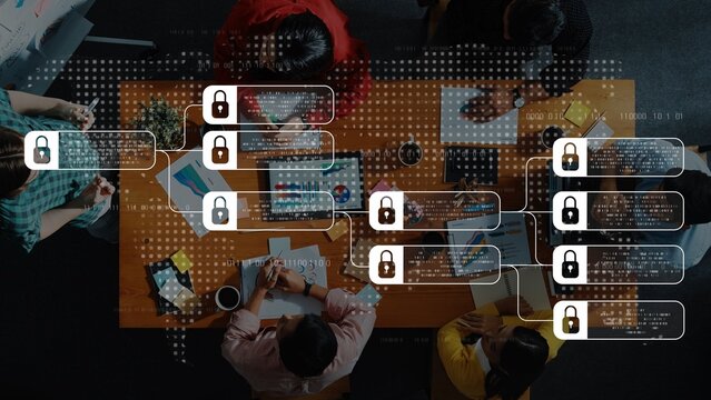 An overhead view of a diverse team engaging in collaborative project development, showcasing data security elements and modern technology in a creative workspace. Raster