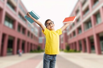 Happy child boy in class with book and glasses
