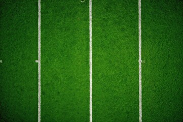 Fototapeta premium Aerial shot of a vibrant green football field highlighting the 30-yard line with white markings.