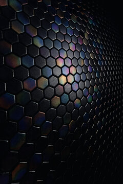 Abstract dark background with hexagonal tiles and soft rainbow reflections. The gradient lighting and smooth surface create a sleek, futuristic, and slightly mysterious high-tech look.