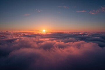 Fototapeta premium Sunset in winter with sunlight piercing through a cloudy sky above a sea of clouds