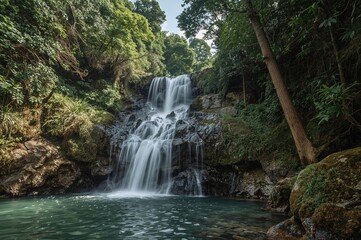 Obraz premium Lush jungle waterfall flowing over moss-covered stones