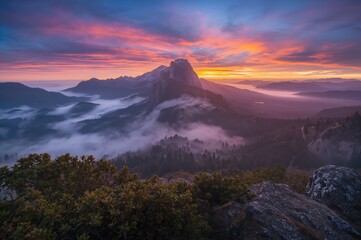 Stunning sunrise over fog-covered hills with vibrant red and orange sunlight