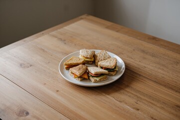 Assorted sandwiches arranged on a platter with blank space for text, set on a rustic wooden surface.