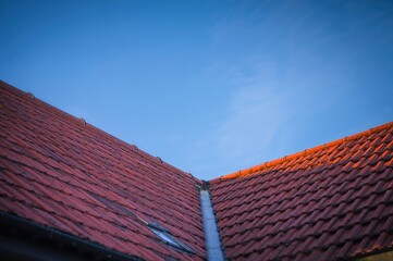Fototapeta premium Sunlight illuminating roof shingles against the sky