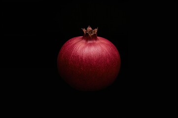 Mature pomegranate against a dark backdrop