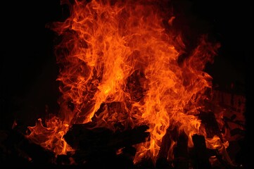 Intense orange fire engulfing wooden logs in a furnace.