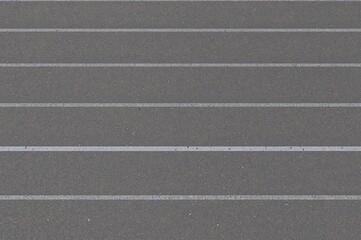 Fototapeta premium Athlete Positioned on Starting Line of Running Track, Preparing for Race Challenge on Grey Asphalt Surface