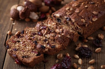 Handcrafted Malt Loaf with Nuts, Raisins, and Cranberries on a Rustic Wood Surface
