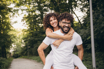Happy multi ethnic couple piggybacking in a park